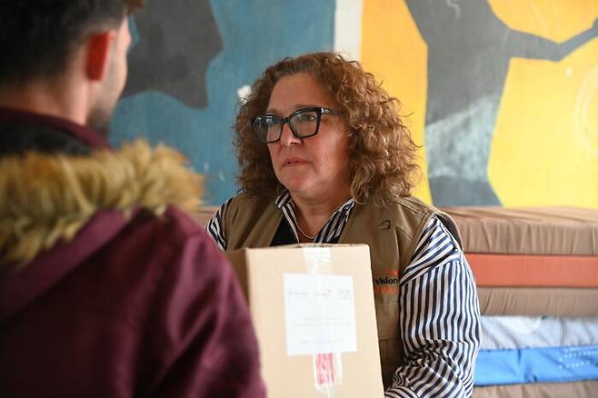 지난 18일 레바논 수도 베이루트 인근 셸터(대피소)로 쓰이고 있는 한 학교에서 한 레바논 피란민에게 하이디 프랜시스 디드리히 레바논 월드비전 회장이 구호물자를 전달하고 있다. 월드비전 제공