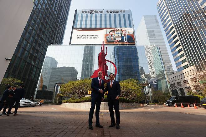 지난 17일 한국투자증권 여의도 본사 앞에서 댄 왓킨스 JP모건자산운용 아시아태평양 대표(왼쪽)와 김성환 한국투자증권 대표가 기념 촬영을 하고 있다. 두 회사는 이날 전략적 업무협약(MOU)을 맺었다. 한국투자증권 제공