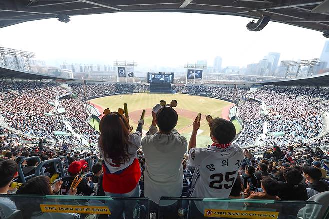 Doosan Bears fans cheer during a KBO preseason game against the Kia Tigers at Jamsil Baseball Stadium in Songpa District, southern Seoul, on March 22. [NEWS1]
