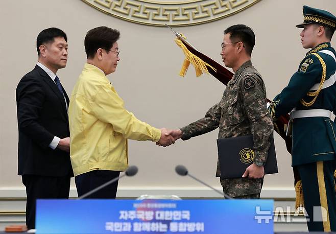 [서울=뉴시스] 고범준 기자 = 이재명 대통령이 23일 청와대에서 열린 제59차 중앙통합방위회의에서 36보병사단에 대통령 단체표창을 수여한 뒤 이동식 제36보병사단장과 악수하고 있다. 2026.03.23. bjko@newsis.com