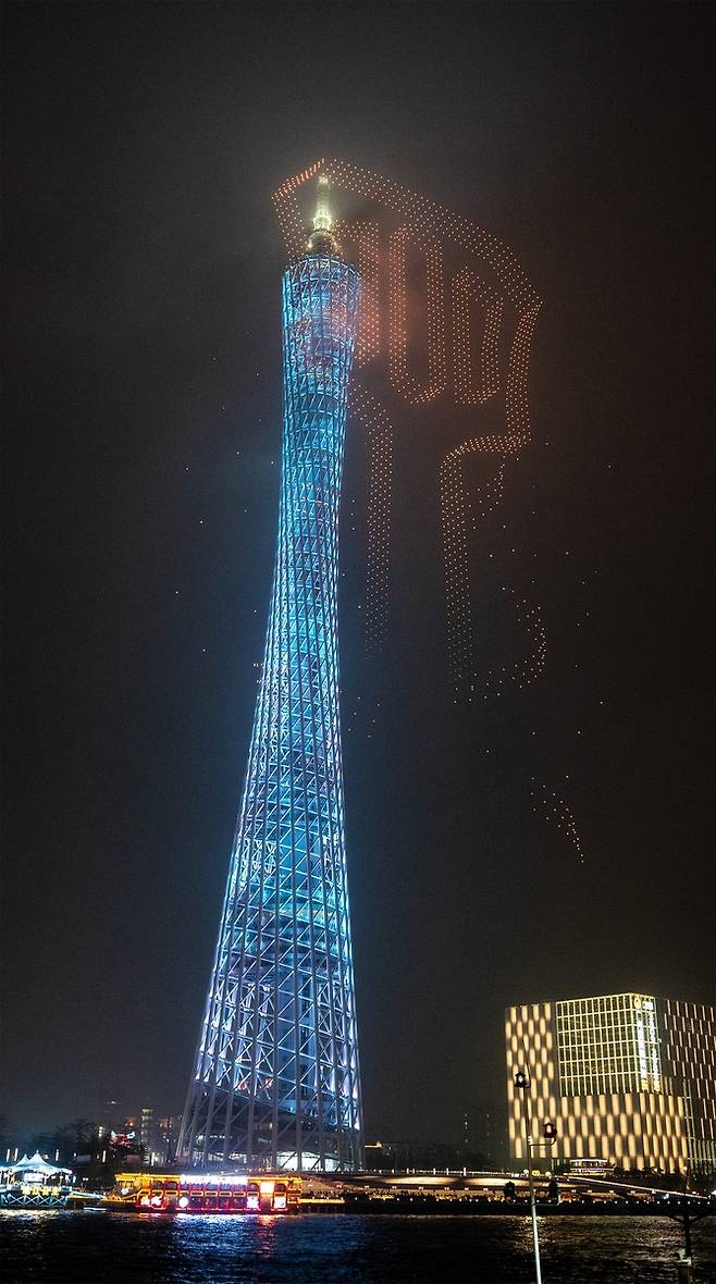 광저우 타워 수놓은 '황금 뒤집개'     (광저우=연합뉴스) 김주환 기자 = 21일 밤 중국 광저우 톈허구 광저우 타워에 라이엇게임즈가 리그 오브 레전드(LoL) 전략적 팀 전투(TFT) 대회를 기념해 진행한 드론 쇼가 펼쳐지고 있다. 2026.3.22 jujuk@yna.co.kr