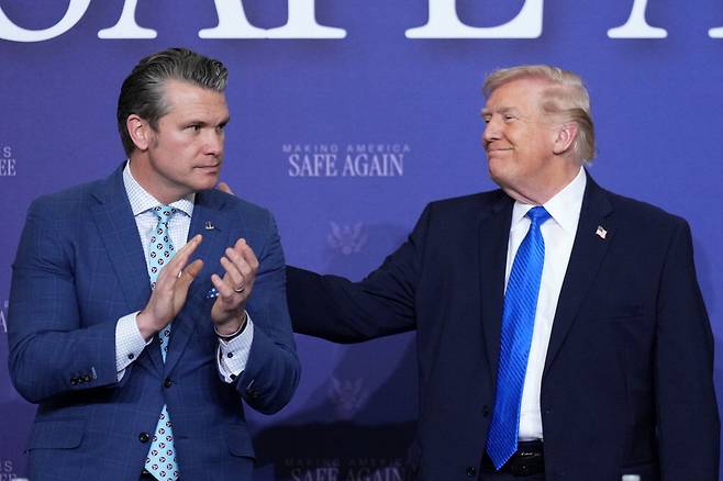 전쟁부 장관 격려하는 트럼프도널드 트럼프 대통령(오른쪽)이 23일(현지시간) 미국 테네시주 멤피스에 있는 주방위군 기지에서 열린 회의에서 피트 헤그세스 전쟁부(옛 국방부) 장관의 등을 두드려주고 있다.  AP연합뉴스