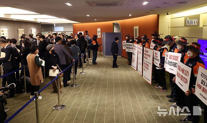 [서울=뉴시스] 최진석 기자 = 24일 오전 서울 중구 코리아나호텔 제 52기 고려아연 정기 주주총회주총장 입구에서 고려아연노조원들이 입장을 기다리는 주주들 바라보며 피켓을 들고 있다. (공동취재) 2026.03.24. photo@newsis.com