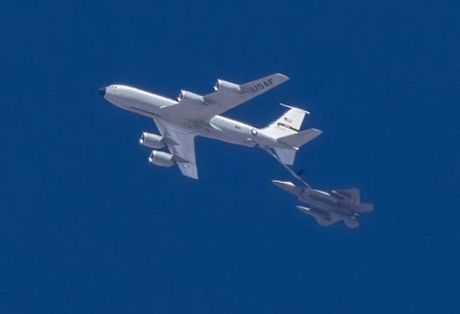 신형 저피탐 외부 연료탱크와 적외선 센서 포드로 추정되는 장비를 단 미 공군 F-22 랩터 전투기가 시험지원 공중급유기 NKC-135와 함께 비행하고 있다. 재로드 해밀턴