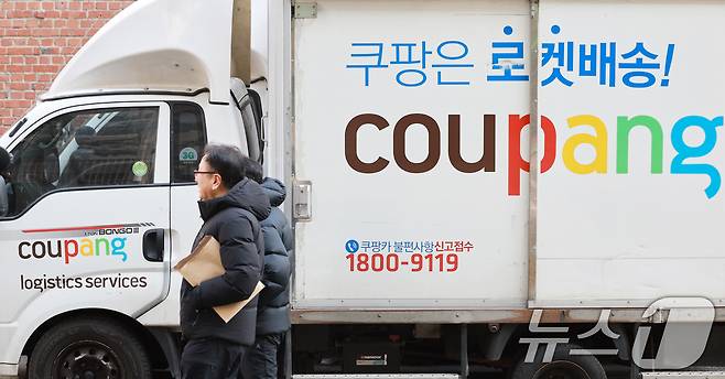 서울시내에 주차된 쿠팡배송 차량 앞을 시민들이 지나가고 있다. ⓒ 뉴스1