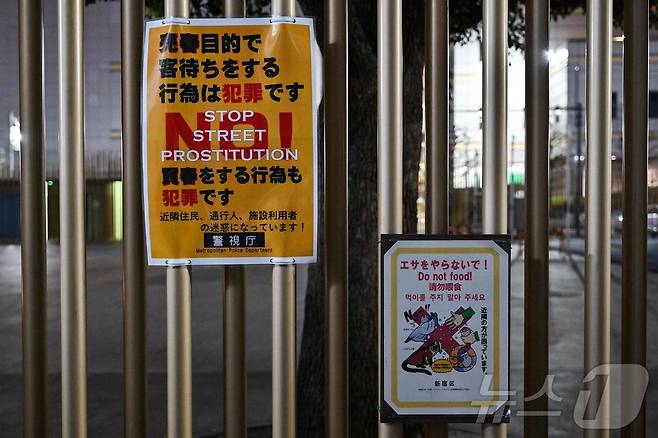 2025년 3월 31일 도쿄 신주쿠구 가부키초 유흥가에 위치한 오쿠보 공원에 길거리 성매매에 대해 경고하는 경찰 안내문(왼쪽)이 붙어 있다. 2025.03.31. ⓒ AFP=뉴스1
