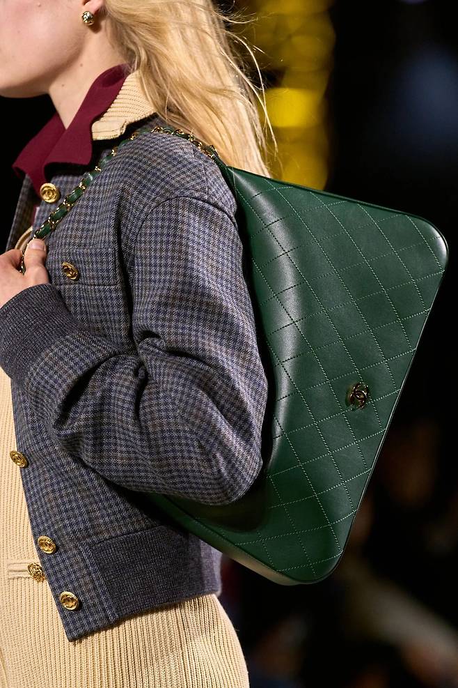 격자 무늬 점퍼와 스타일링 된 그린 컬러 숄더 백.