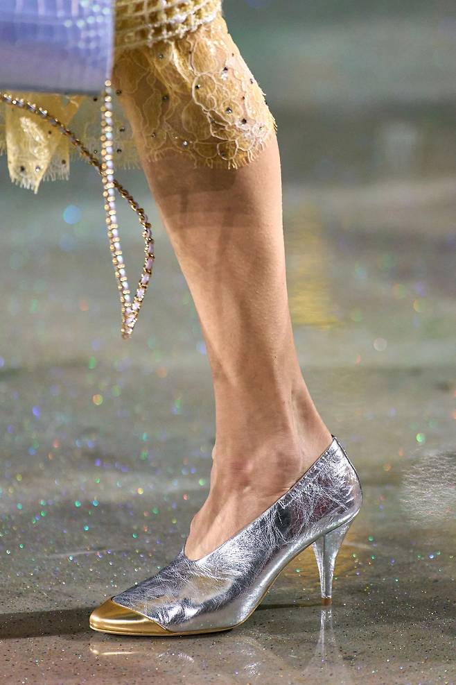 메탈릭 소재로 재해석된 투톤 슈즈는 앞코 라인을 변형해 날렵하고 세련된 인상을 준다.