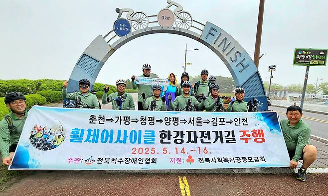춘천부터 인천에 이르는 한강 자전거도로를 휠체어 사이클로 완주한 참가자들이 기념 촬영을 하고 있다. 사랑의열매 제공