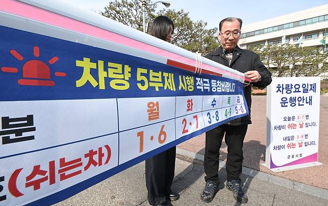 24일 경기 군포시청 주차장 입구에서 직원들이 내일부터 시행하는 차량 5부제를 앞두고 안내문을 설치하고 있다. [사진 | 뉴시스]
