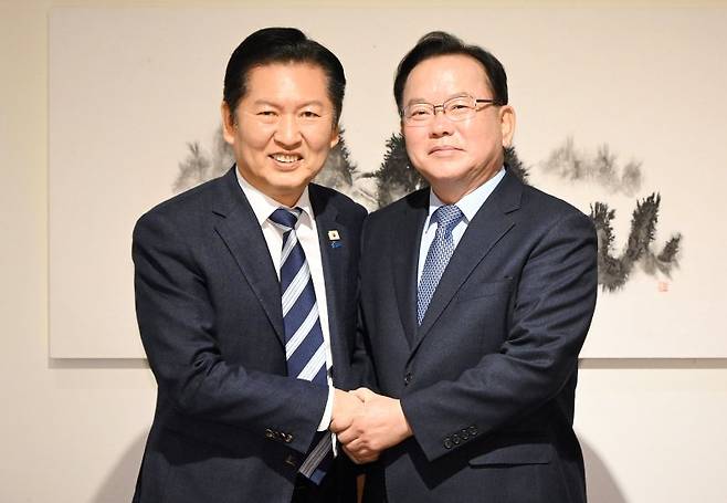 정청래 더불어민주당 대표(왼쪽)와 김부겸 전 국무총리가 26일 서울 중구 달개비에서 회동 전 손을 맞잡고 있다. 연합뉴스