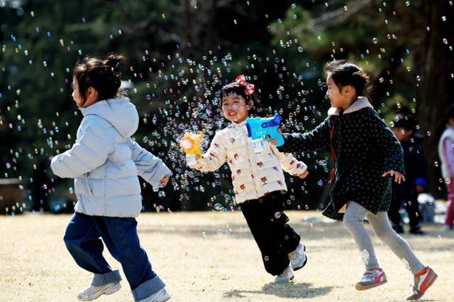 봄 날씨를 보인 13일 광주 북구청 직장어린이집 아이들이 전남대학교 캠퍼스 잔디 광장에서 비눗방울 놀이를 하며 즐거운 시간을 보내고 있다. 광주 북구 제공