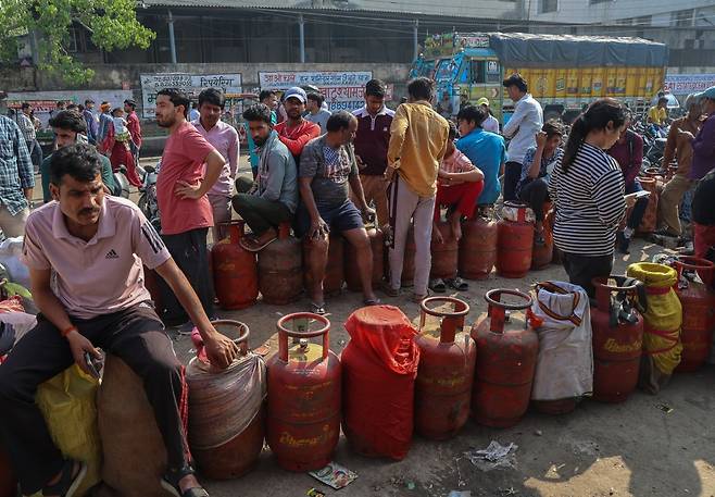 지난 24일(현지시간) 인도 우타르프라데시주 노이다의 한 가스 충전소에서 사람들이 액화석유가스(LPG)통을 채우기 위해 줄 서 있다. EPA연합뉴스