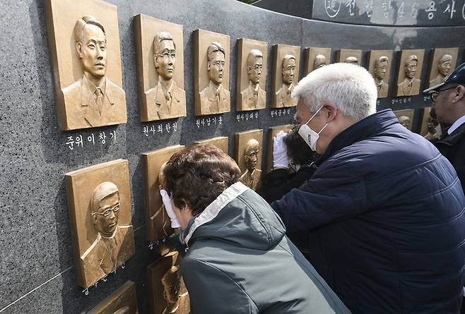 26일 경기도 평택시 해군 제2함대 사령부에서 열린 ‘제16주기 천안함 46용사 추모식’에서 유가족이 추모비에 새겨진 얼굴을 어루만지고 있다. [사진공동취재단]