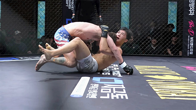 미국팀 레이크 지가 2026년 3월 경기도 오산시 종합격투기 국가대항전 ‘블랙컵’ 준준결승 밴텀급 경기에서 대한민국 알파 ‘리바이’ 김유찬을 넘어뜨리고 있다. 블랙컵 첫 시즌은 유튜브 채널 ‘블랙컴뱃’ 유료 멤버십 단독 생중계다. 사진=이데아 파라곤