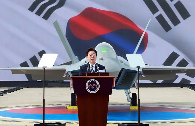 이재명 대통령이 25일 경남 사천 한국항공우주산업(KAI)에서 열린 KF-21 양산 1호기 출고식에서 격려사를 하고 있다. [청와대통신사진기자단]