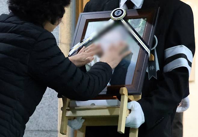 지난 3월25일 대전 대덕구 안전공업 화재 참사 희생자 발인식에서 고인의 모친이 영정 사진 속 얼굴을 쓰다듬고 있다. 대전=연합뉴스