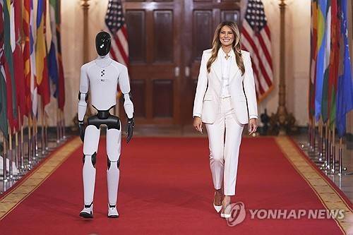 로봇과 함께 'AI 아동교육' 관련 회의에 입장하는 멜라니아 여사 [워싱턴 AP=연합뉴스. 재판매 및 DB 금지]