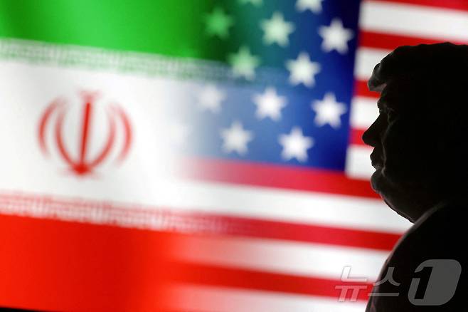 도널드 트럼프 미국 대통령의 뒤로 미국과 이란 국기가 나란히 펼쳐진 모습. 2025.01.15 ⓒ 로이터=뉴스1