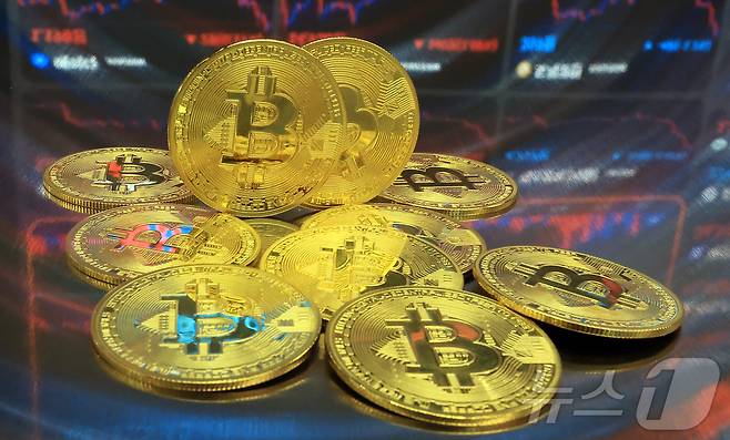 지난해 7월  오후 서울 강남구 서초구 빗썸라운지 강남본점에서 비트코인 모형이 놓인 바닥에 코인 시세 그래프가 비치는 모습. 2025.7.23 ⓒ 뉴스1 김진환 기자