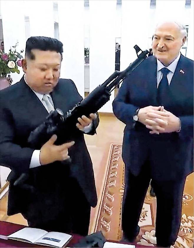 26일 알렉산드르 루카셴코(오른쪽) 벨라루스 대통령과 만난 북한 김정은이 선물받은 소총을 살펴보는 모습. 미국과 이란의 전쟁에 국제사회의 관심이 쏠린 사이 우크라이나를 겨냥한 러시아의 공세가 거세지고, 러시아·북한·벨라루스가 밀착하고 있다. /AFP 연합뉴스