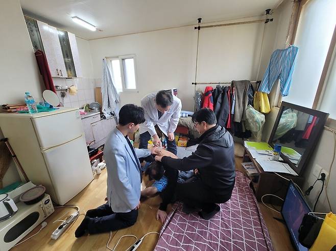 ▲ 5일 이정환 의사와 이윤성 간호사, 김현수 사회복지사가 춘천 효자동에 거주하는 김상훈(68·가명) 씨의 집에 방문했다. 이정환 의사가 김 씨에게 통증 주사를 놓고 있다.