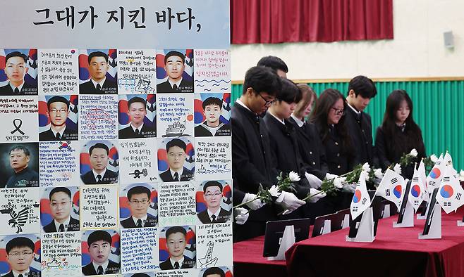 제11회 서해수호의 날을 앞둔 지난 25일 천안함 피격으로 산화한 고&nbsp;박경수 상사 모교인 경기 수원시 팔달구 삼일공업고등학교에서 열린 ‘서해수호 영웅 고 박경수 상사 추모식’에서 학생들과 내빈들이 서해수호 55용사를 기리며 묵념을 하고 있다. 수원=뉴스1