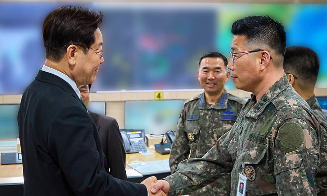 이재명 대통령이 27일 서울 용산 국방부에서 전군주요지휘관회의를 마친 뒤 지휘통제실을 찾아 조성현 대령을 격려하며 악수하고 있다. 12·3 비상계엄 당시 수도방위사령부 제1경비단장이었던 조성현 대령은 국회로 출동하는 병력에 '서강대교를 넘지 말라'고 지시해 불법 계엄을 막는 데 일조했다. 청와대 제공