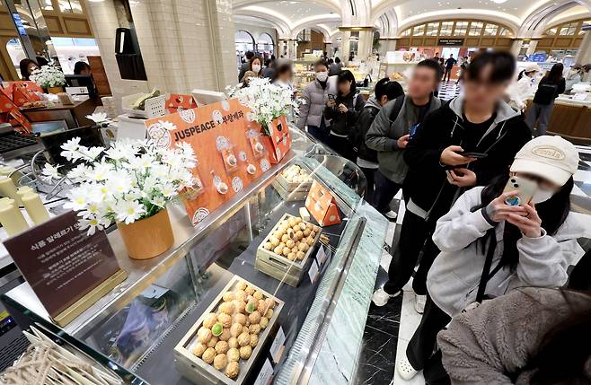 가수 지드래곤(G-DRAGON)이 설립한 저스피스 재단과 80년 전통의 부창제과가 협업한 '데이지 밤(DAISY BOMB) 호두과자'가 정식 출시된 26일 서울 신세계 백화점 강남점 '스위트파크' 팝업스토어 부창제과에서 팬들이 제품을 구매하기 위해 줄을 서고 있다. /뉴시스