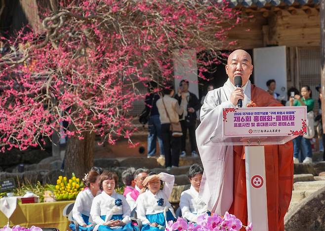 봄을 알리는 홍매화가 활짝 핀 지난 21일 전남 구례군 지리산 화엄사에서 열린 제6회 홍매화 들매화 프로사진 및 휴대폰사진 콘테스트 개막식에서 주지 우석스님 등 참석자들이 합장하고 있다. 연합뉴스