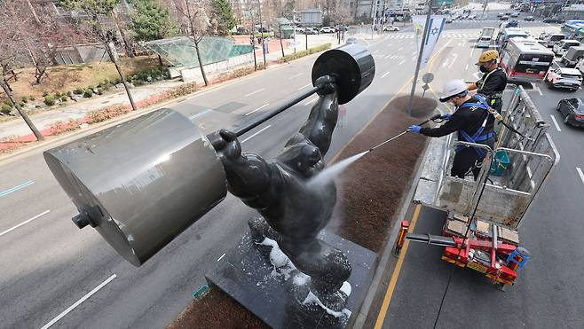 25일 서울 송파구 잠실동 일대에서 송파구 관계자들이 올림픽 상징 조형물 세척 작업을 하고 있다. [연합]