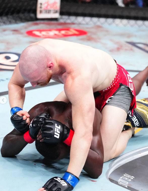 조 파이퍼(위)가 이스라엘 아데산야에게 파운딩 펀치를 퍼붓고 있다. 사진=UFC