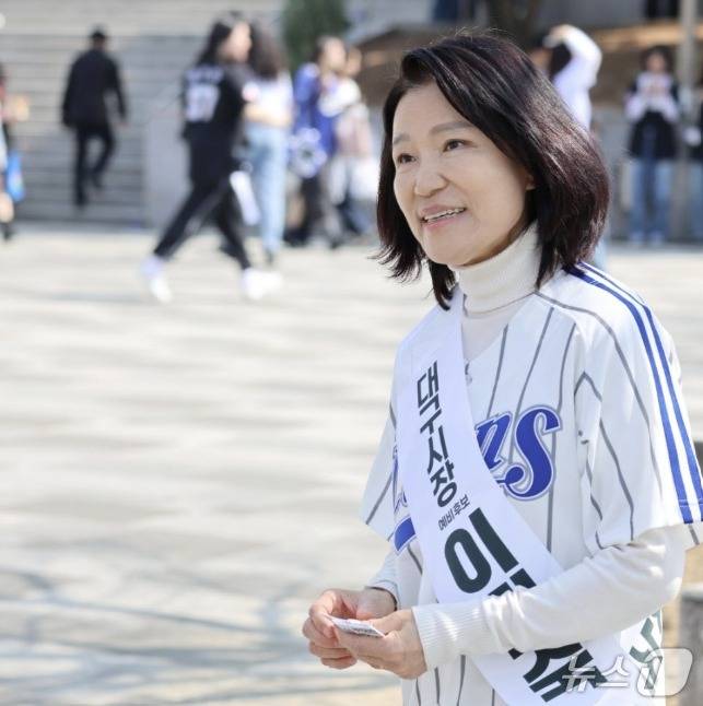 '대구시장 예비후보 이진숙'이라는 어깨띠를 한 이진숙 전 방송통신위원장이 지난 28일 삼성라이온즈-롯데자이언츠와의 프로야구 대구 홈 개막전이 열린 대구라이온즈파크를 찾아 시민들에게 명함을 돌리고 함께 사진을 찍는 등 이름 알리기에 열중했다. (SNS 갈무리) ⓒ 뉴스1