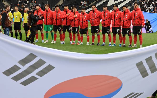 <yonhap photo-0879=""> 국기에 경례하는 한국 선수들 (밀턴킨스[영국]=연합뉴스) 최재구 기자 = 한국축구국가대표팀 선수들이 28일(현지시간) 영국 밀턴킨스 스타디움 MK에서 열린 코트디부아르와 평가전에서 국기에 경례하고 있다. 2026.3.29 jjaeck9@yna.co.kr/2026-03-29 02:27:13/ 연합뉴스</yonhap>
