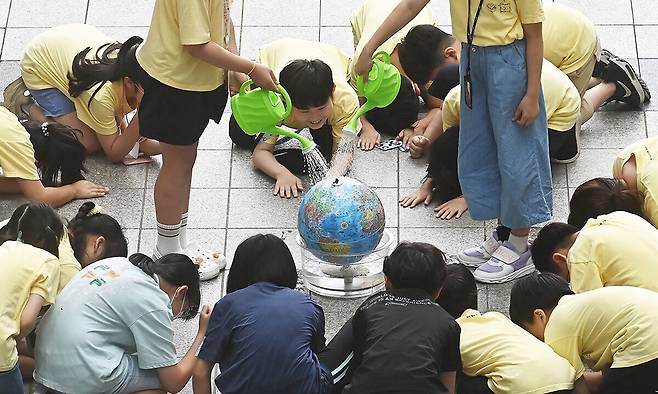 경기도 수원시 팔달구 수원시청에서 신영초등학교 학생들이 수원환경운동연합, 다산인권센터와 함께 기후 위기 대응을 촉구하는 퍼포먼스'를 하고 있다. 뉴시스