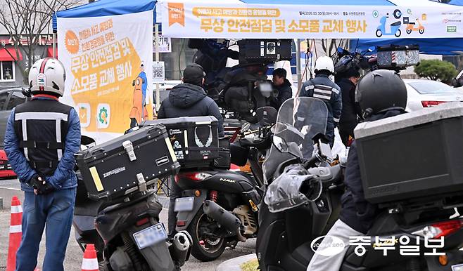 30일 오전 수원시 장안구 수원종합운동장 주차장에서 열린 '이륜차 사고 예방과 친환경 운행을 위한 무상 안전 점검 및 소모품 교체 행사'에서 관계자들이 오토바이를 점검하고 있다. 김경민기자