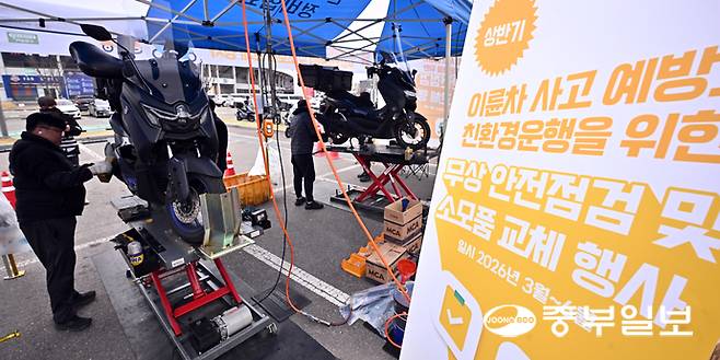 30일 오전 수원시 장안구 수원종합운동장 주차장에서 열린 '이륜차 사고 예방과 친환경 운행을 위한 무상 안전 점검 및 소모품 교체 행사'에서 관계자들이 오토바이를 점검하고 있다. 김경민기자