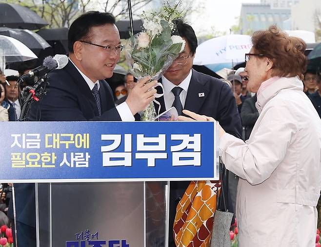 더불어민주당 소속 김부겸 전 국무총리가 30일 오후 대구 중구 동성로 2·28기념중앙공원에서 대구시장 선거 출마를 밝히던 중 한 시민으로부터 꽃다발을 받고 있다. 연합뉴스