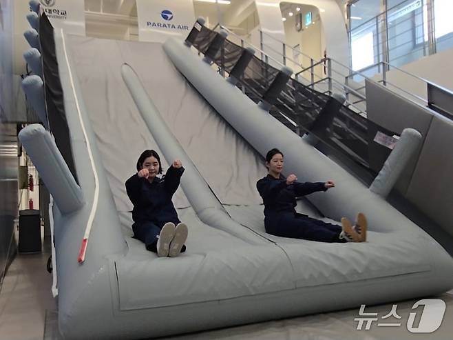 27일 경기 부천 유한대학교에 문을 연 파라타항공 항공훈련센터 내 비상 탈출 슬라이드 훈련장에서 파라타항공 승무원들이 A330-200에 탑재된 높이 4m 내외의 비상 탈출 슬라이드를 타고 낙하하고 있다. 2026.3.27/뉴스1 김성식 기자