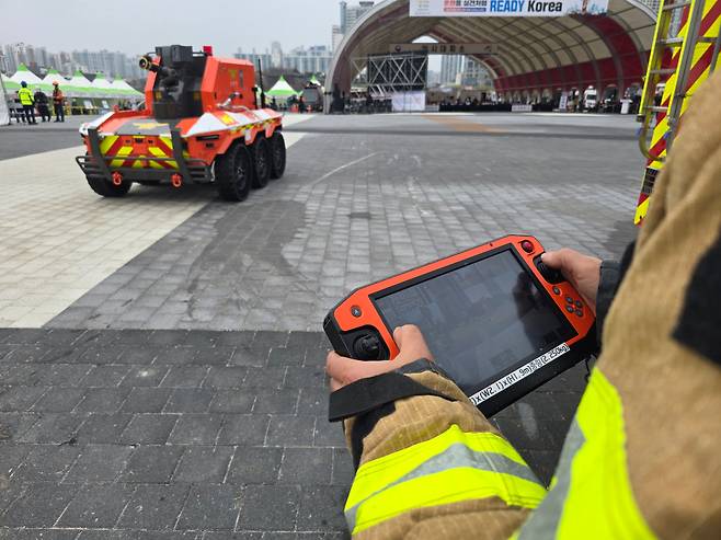 지난 25일 울산 태화강 국가정원 둔지에서 ‘레디 코리아(READY Korea) 훈련’ 중 박종일 영남119 특수구조대 소방위가 조작기로 무인소방로봇을 움직이고 있다. /권오은 기자