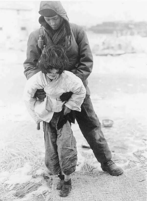 6·25 전쟁 당시 한 어린이가 부상을 당한 채 미군의 부축을 받고 있다. 미국 국립문서관리청(NARA) 소장. ‘유령 연구’의 원서 표지에 쓰인 사진. 동녘 제공