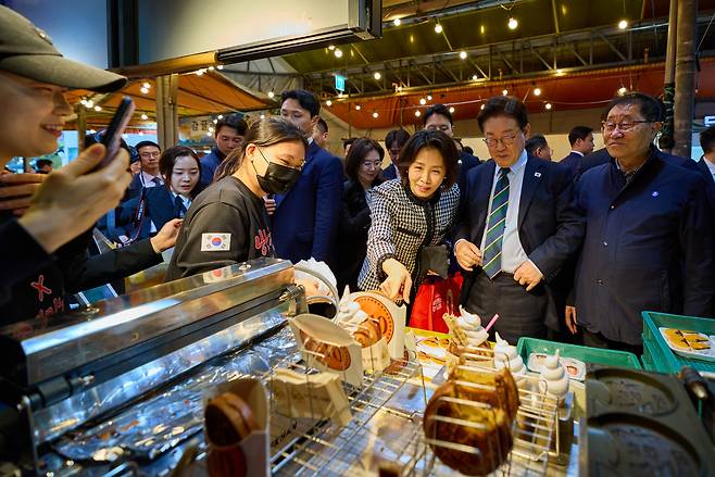 이재명 대통령이 30일 제주 타운홀미팅을 마친 뒤 김혜경 여사와 함께 제주시 동문시장을 찾아 간식을 구매하고 있다. 2026.3.30 [청와대 제공. 재판매 및 DB 금지] <연합뉴스>