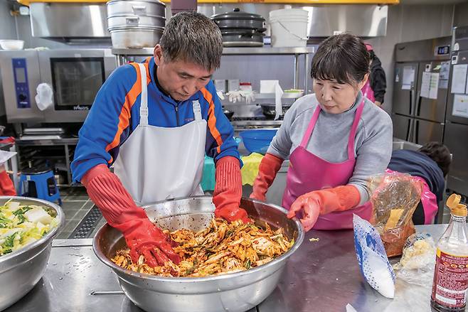 3월17일 서울 양천구 신정종합사회복지관에서 여성 자원봉사자와 지역 장년 남성이 고립 위험이 높은 중장년 1인 가구 남성을 위해 '공유 냉장고'에 비치할 밑반찬을 조리하고 있다. ⓒ시사저널 최준필