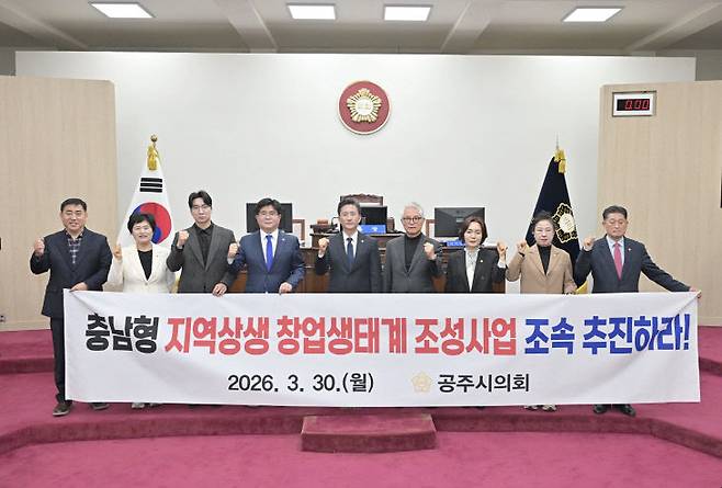 공주시의회 의원들이 3월 30일 제265회 임시회 제2차 본회의장에서 '충남형 지역상생 창업생태계 조성사업 조속 추진'을 촉구하는 문구가 적힌 프래카드를 들고 사업추진을 촉구하고 있다. (사진=공주시의회 제공)