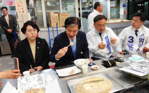 조국혁신당 조국 당대표가 29일 영월 서부시장에서 신장식 국회의원 등과 함께 영월의 대표 먹거리인 전병을 시식하고 있다.