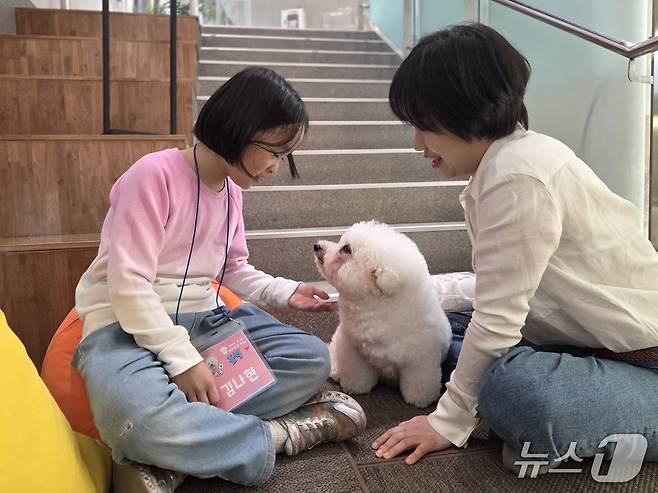 홀릭이의 반려인인 조수민 치료사(오른쪽)가 프로그램 시작에 앞서 김나현 어린이에게 반려견과 인사하는 방법을 교육하고 있다. ⓒ 뉴스1 한송아 기자
