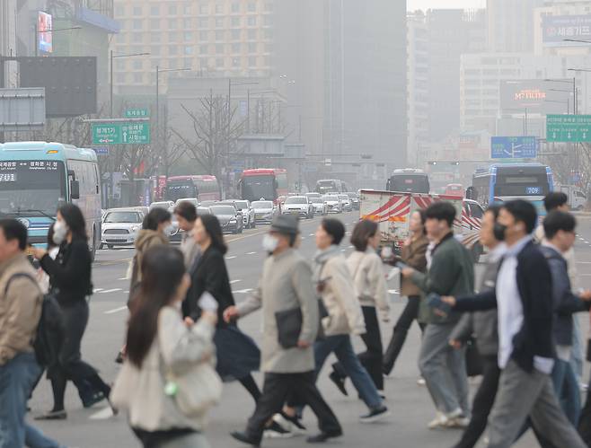 27일 서울 광화문 세종대로 사거리에서 시민들이 마스크를 쓴 채 걸어가고 있다. 연합뉴스