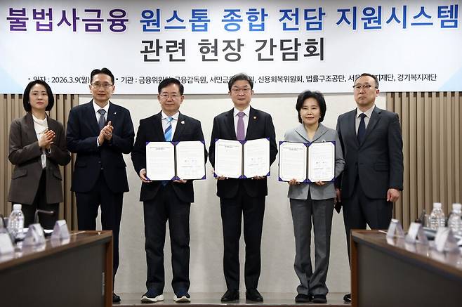 이억원 금융위원장(오른쪽 세 번째)을 비롯한 내빈들이 지난달 9일 서울 중구 서민금융통합지원센터에서 열린 불법사금융 원스톱 종합 전담 지원시스템 관련 현장 간담회에서 업무 협약 체결식을 마친 후 기념촬영을 하고 있다. [사진=연합뉴스]