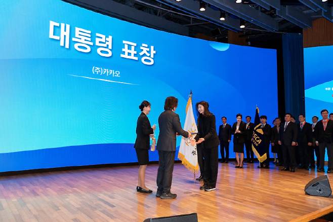 카카오는 1일 서울 중구 대한상공회의소에서 열린 제25회 공정거래의 날 기념식에서 모바일 상품권 시장의 상생 협력과 소상공인 디지털 전환에 기여한 공로를 인정받아 대통령 표창을 수상했다고 밝혔다. 주병기 공정거래위원회 위원장으로부터 대통령 표창을 받고 있는 카카오 정신아 대표(오른쪽).