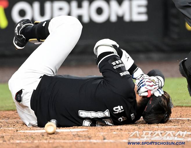 허경민이 엄상백의 투구를 머리에 맞고 얼굴을 두 손으로 감싸쥔 채 쓰러져 있다.